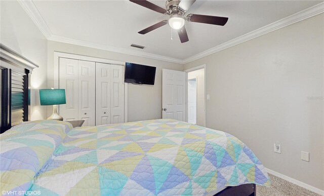 carpeted bedroom featuring visible vents, crown molding, ceiling fan, baseboards, and a closet
