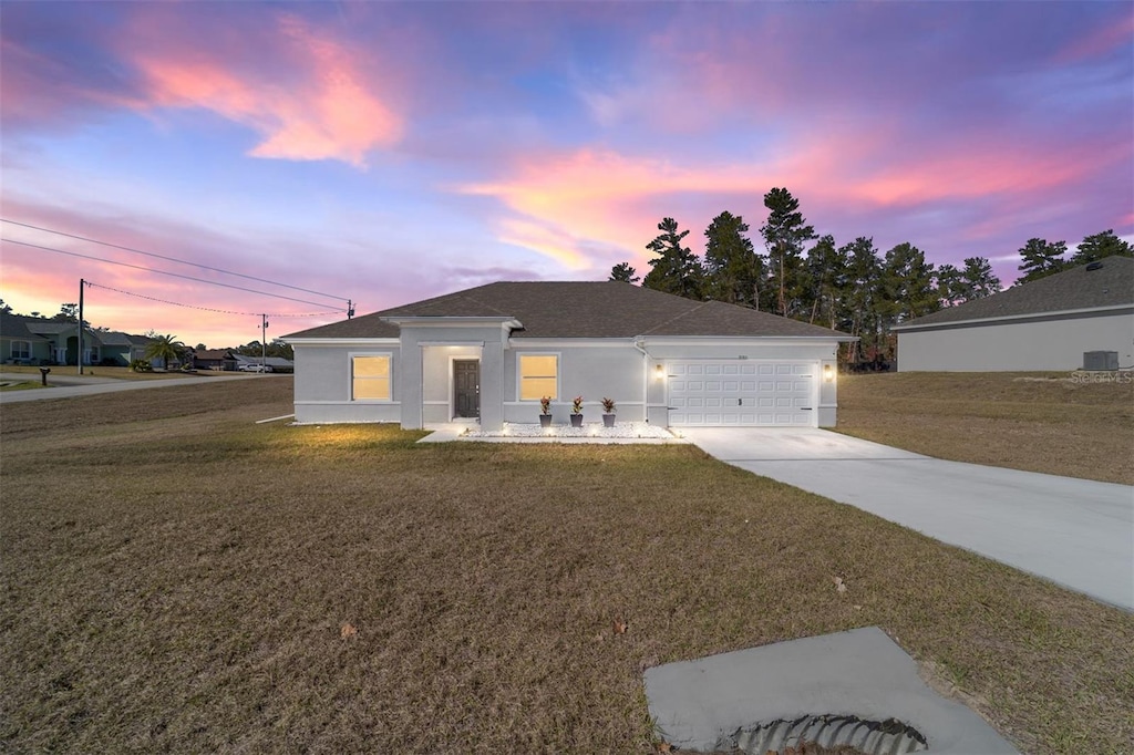 view of front of home featuring a garage and a lawn