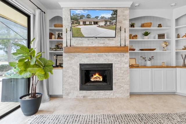 living room with crown molding and a stone fireplace