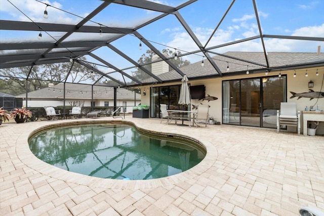 view of swimming pool with a patio area and glass enclosure