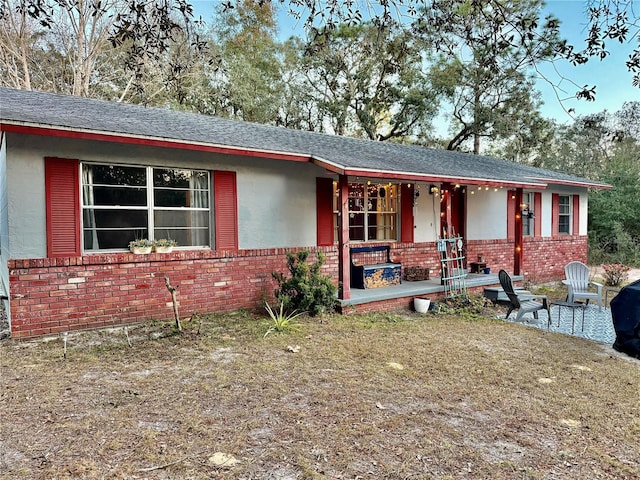 5625 SW 181st Ct, Dunnellon, FL 34432 - ranch-style house with brick siding, a porch, and roof with shingles