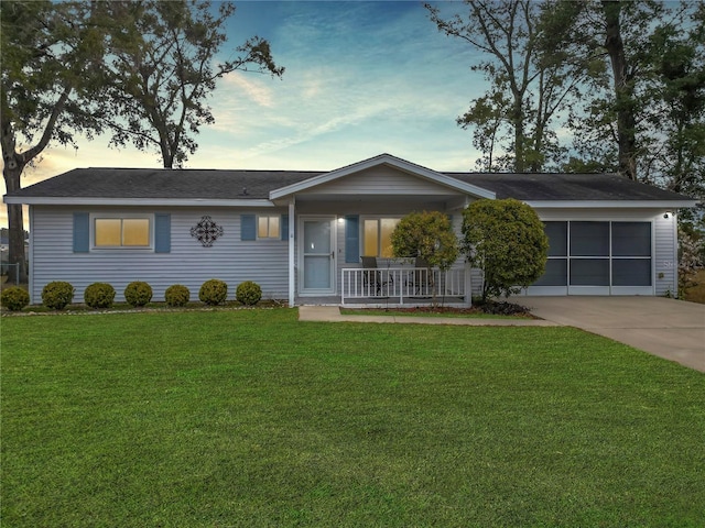 ranch-style house with a garage, a yard, and covered porch