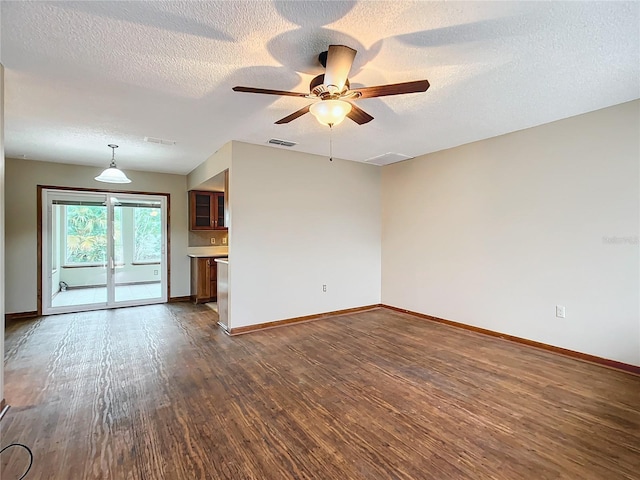 unfurnished living room with ceiling fan, dark hardwood / wood-style flooring, and a textured ceiling