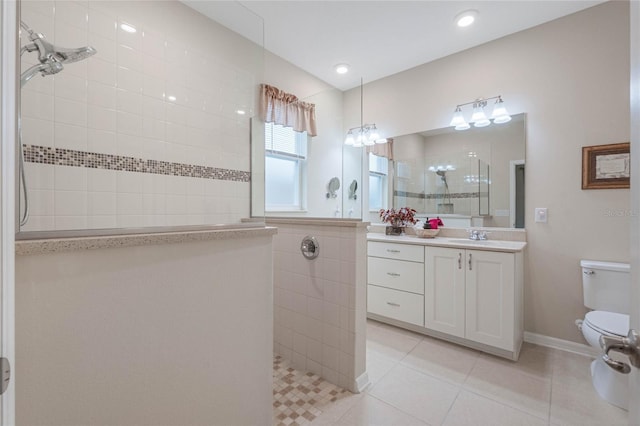 bathroom with vanity, tile patterned floors, toilet, and tiled shower