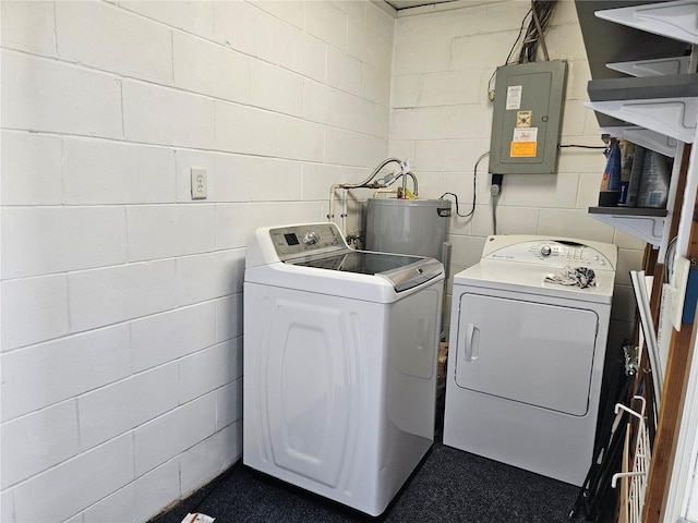 clothes washing area featuring water heater, separate washer and dryer, and electric panel