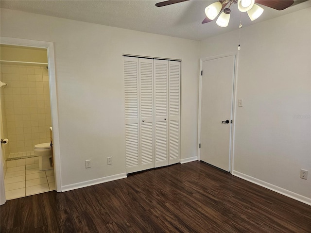 unfurnished bedroom with dark hardwood / wood-style floors, connected bathroom, ceiling fan, a textured ceiling, and a closet