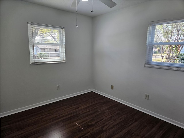 empty room featuring ceiling fan, plenty of natural light, and dark hardwood / wood-style flooring