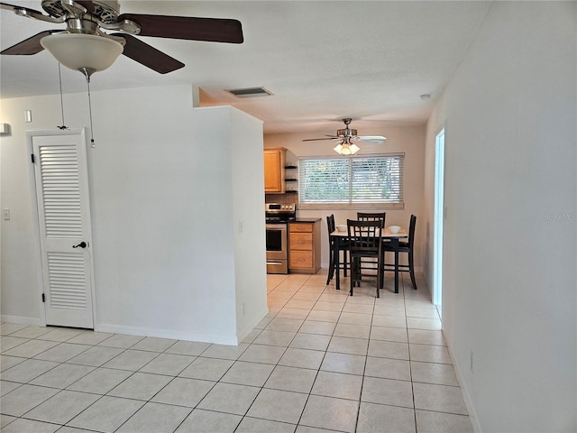 kitchen with tasteful backsplash, light tile patterned floors, ceiling fan, and stainless steel electric range oven