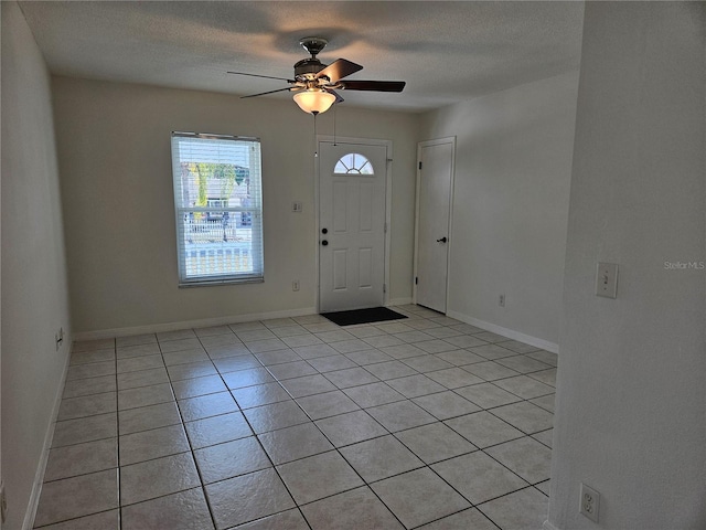 tiled foyer featuring ceiling fan and a textured ceiling