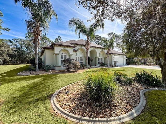 mediterranean / spanish-style home featuring a garage and a front lawn