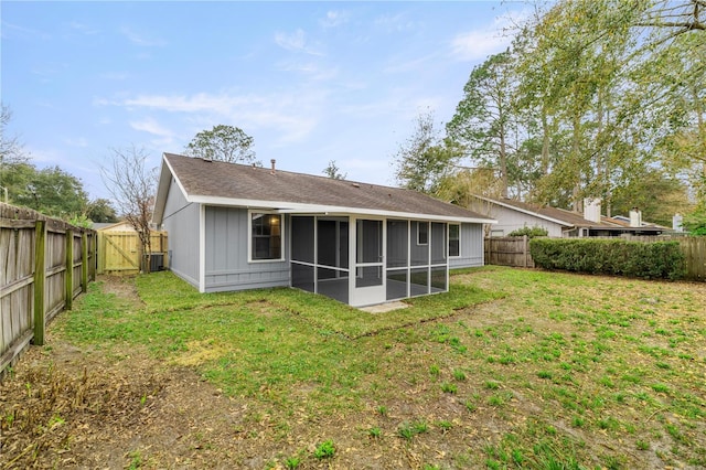 rear view of property featuring a sunroom, central AC unit, and a lawn