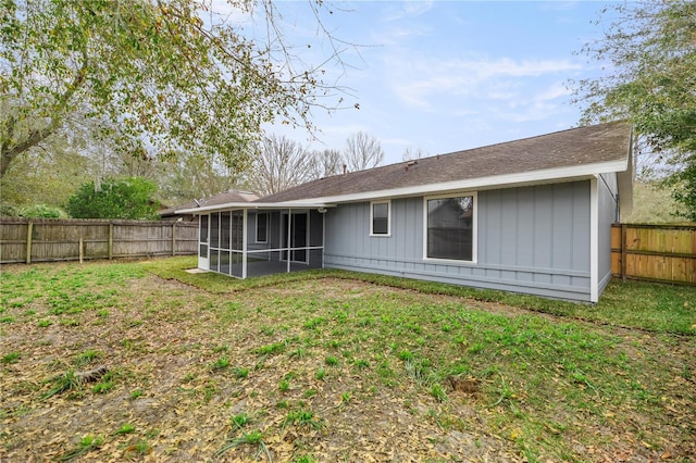 back of house featuring a sunroom and a yard