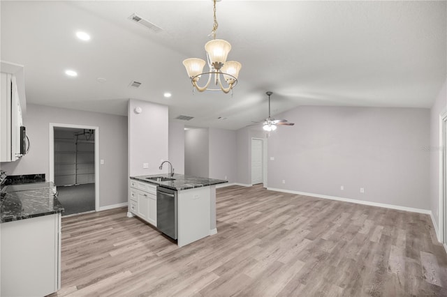 kitchen with sink, white cabinetry, hanging light fixtures, dark stone countertops, and dishwasher