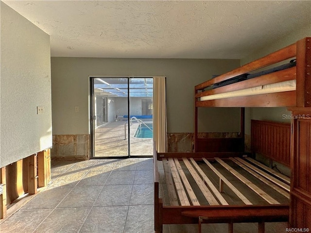 unfurnished bedroom featuring access to exterior and a textured ceiling