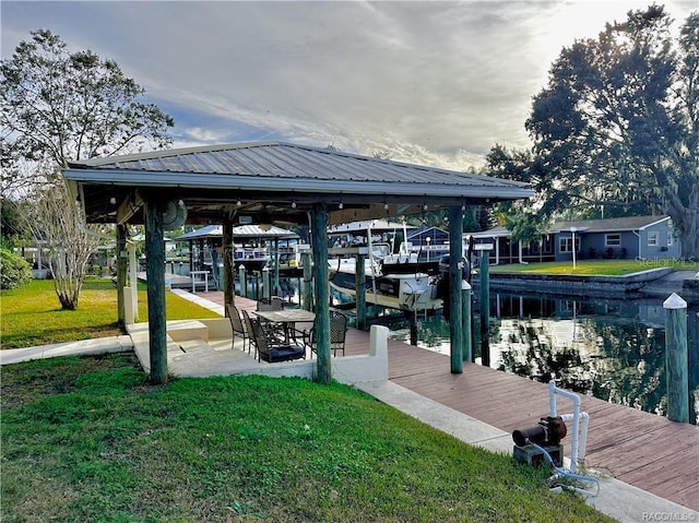 dock area featuring a water view, a yard, and boat lift