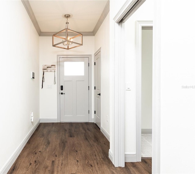 doorway to outside with ornamental molding, an inviting chandelier, dark wood finished floors, and baseboards