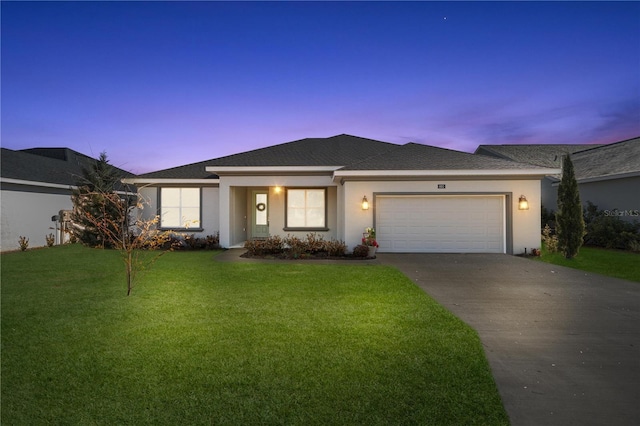 view of front of house featuring a garage and a lawn