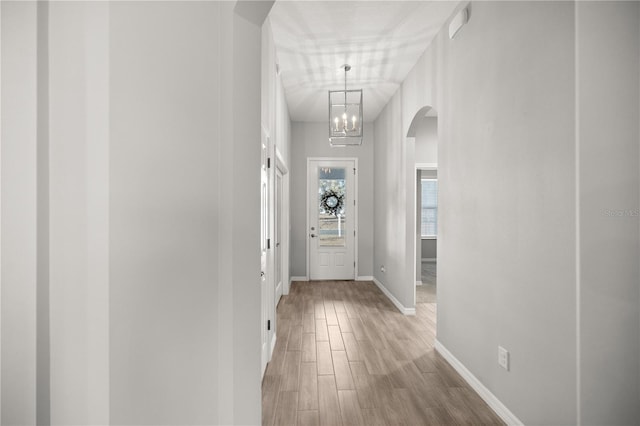 hall featuring an inviting chandelier and hardwood / wood-style floors