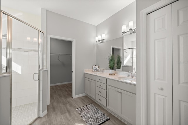 bathroom with a shower with door, vanity, and wood-type flooring