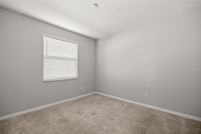 unfurnished room featuring light carpet and a textured ceiling