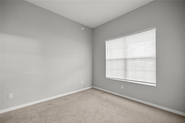 unfurnished room with lofted ceiling and light colored carpet