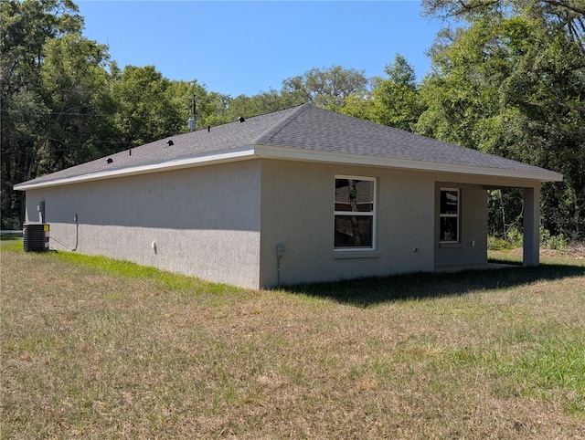 14259 SE 33rd Ter, Summerfield, FL 34491 - view of side of home featuring stucco siding, a yard, cooling unit, and a shingled roof
