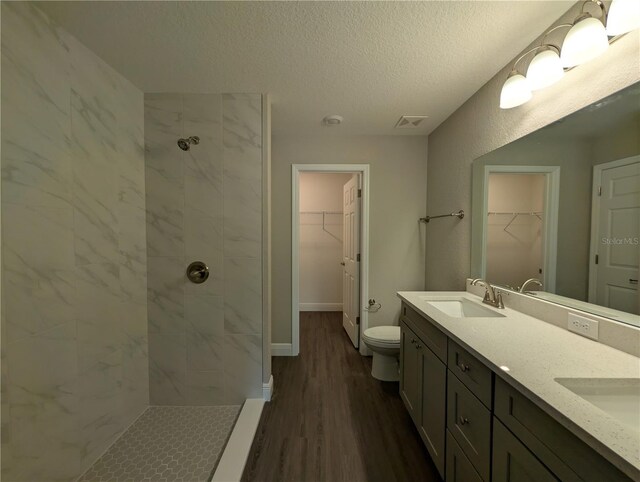 14259 SE 33rd Ter, Summerfield, FL 34491 - full bath featuring wood finished floors, visible vents, a sink, a textured ceiling, and tiled shower