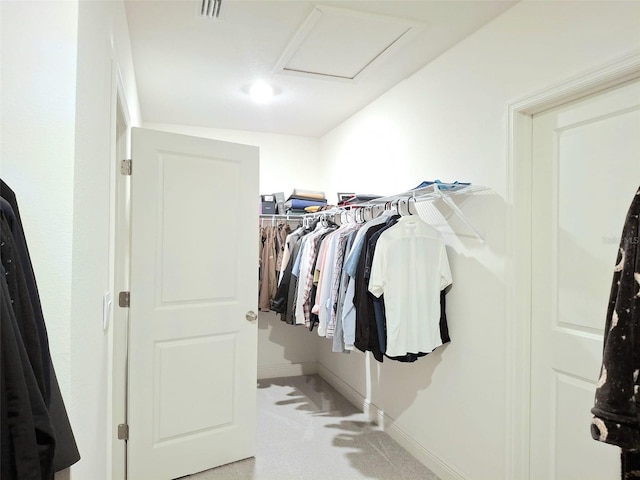 walk in closet featuring light colored carpet