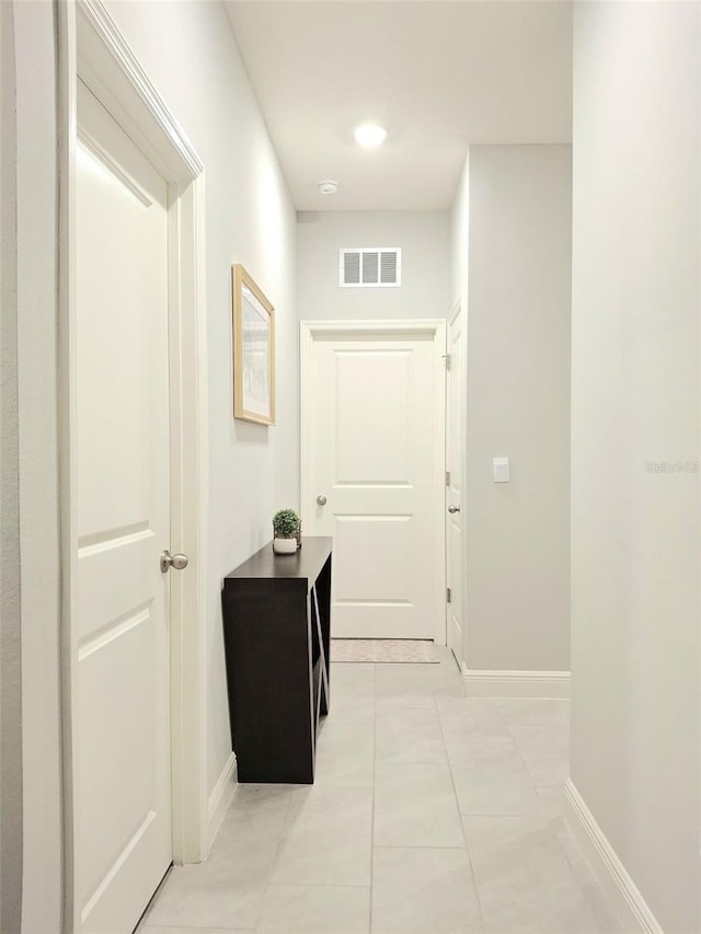 hall featuring light tile patterned flooring