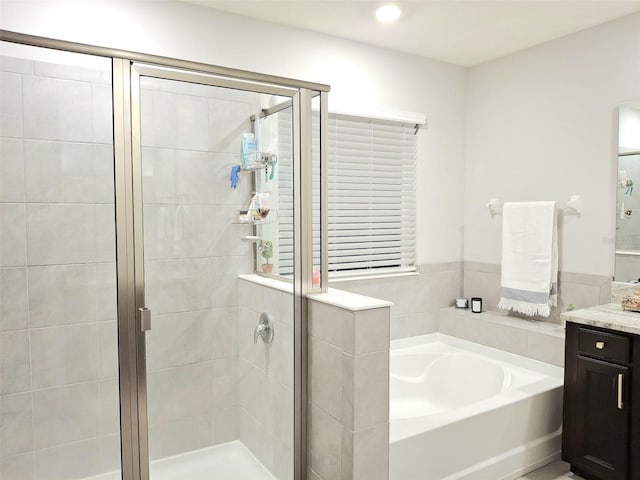 bathroom featuring vanity and independent shower and bath