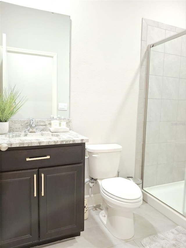 bathroom with vanity, toilet, a shower with shower door, and tile patterned flooring