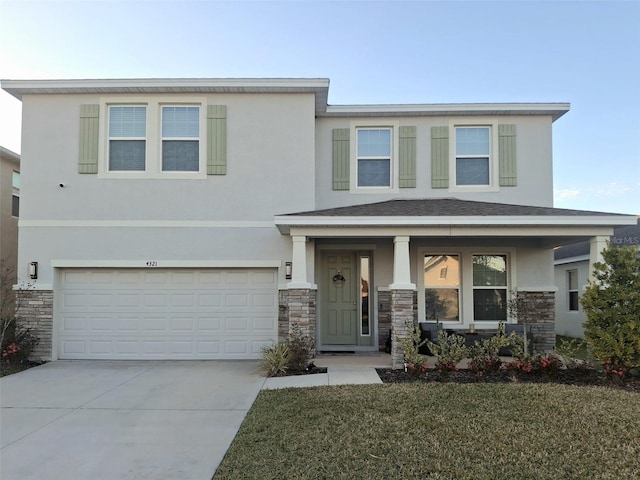 view of front of home featuring a garage, a front lawn, and covered porch