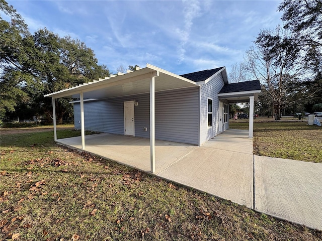 view of side of property featuring a yard and a carport