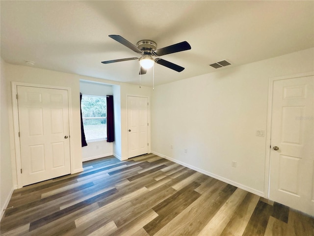 unfurnished bedroom with dark hardwood / wood-style floors and ceiling fan