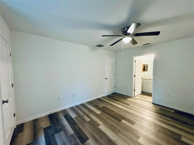 unfurnished bedroom featuring hardwood / wood-style flooring, ceiling fan, and ensuite bathroom