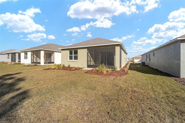 rear view of property with a lawn and a sunroom