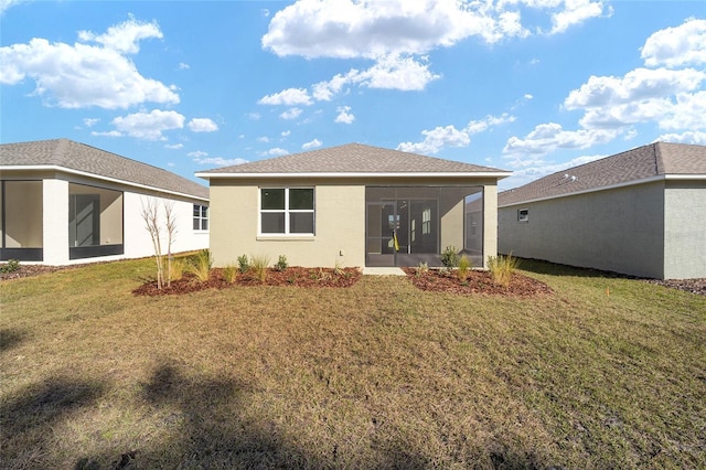 back of house featuring a lawn and a sunroom