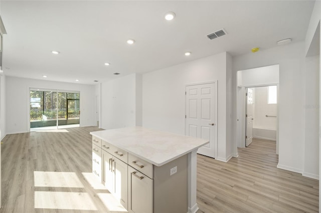 kitchen with a center island, white cabinets, and light wood-type flooring