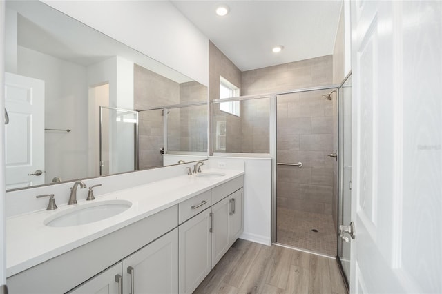 bathroom featuring vanity, hardwood / wood-style flooring, and a shower with door