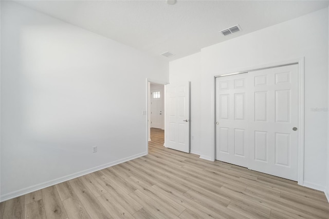 unfurnished bedroom featuring light hardwood / wood-style floors and a closet