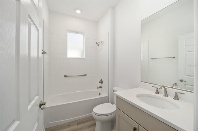 full bathroom featuring tiled shower / bath combo, wood-type flooring, vanity, and toilet