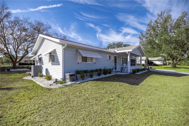 view of front of house with a porch, central AC unit, and a front lawn