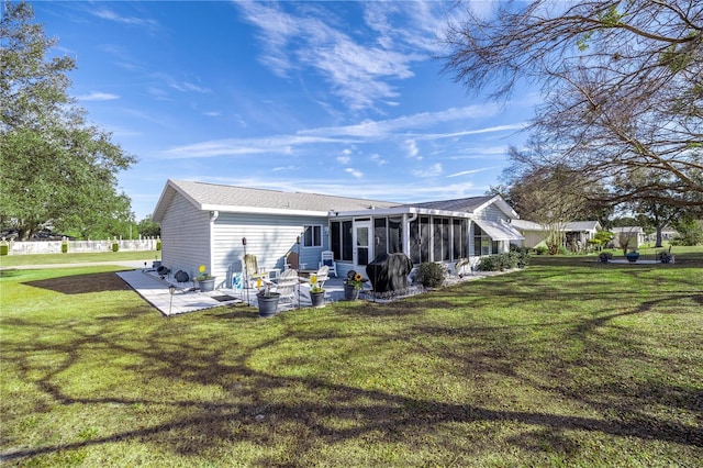 back of house with a yard, a patio area, and a sunroom