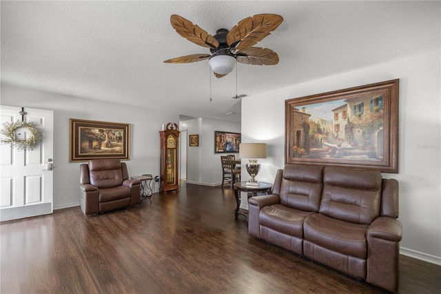 living room with a textured ceiling, dark hardwood / wood-style floors, and ceiling fan