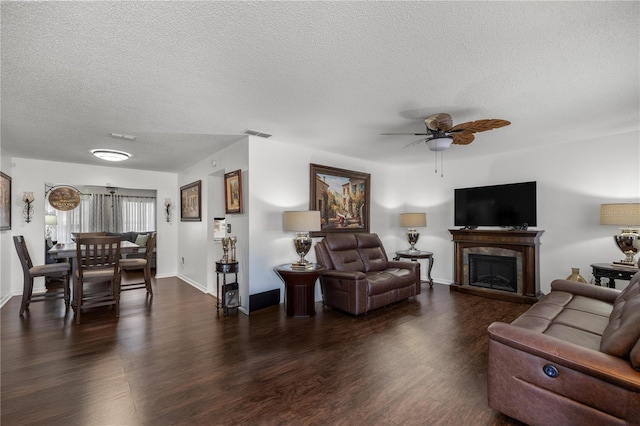 living room featuring a textured ceiling, dark hardwood / wood-style floors, and ceiling fan