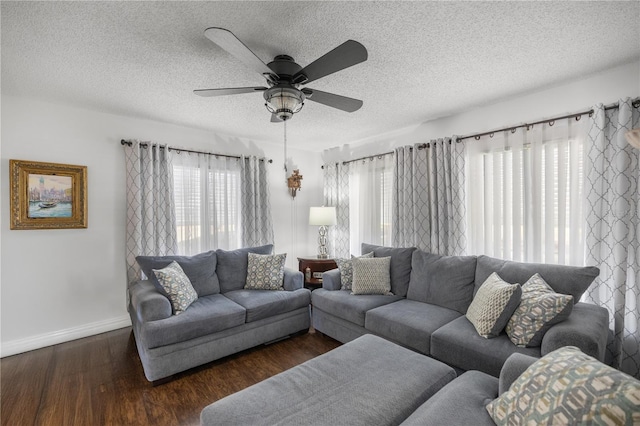 living room with ceiling fan, dark hardwood / wood-style floors, and a textured ceiling