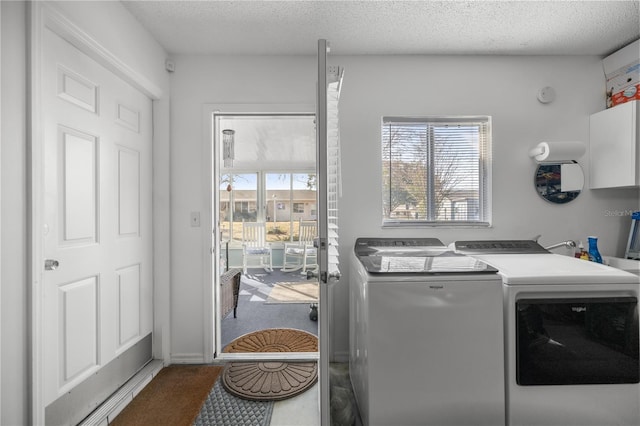 laundry area featuring washer and clothes dryer, cabinets, and a textured ceiling