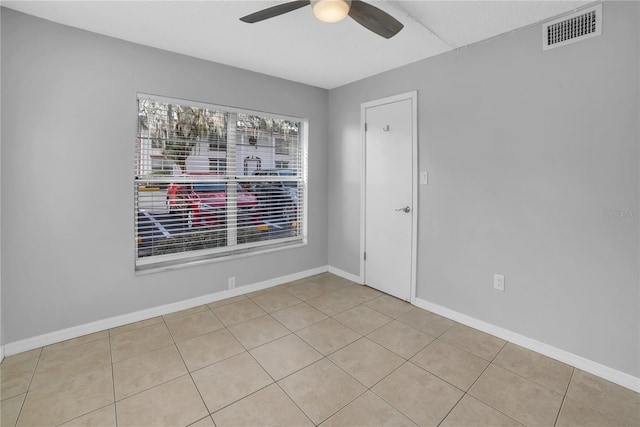 tiled empty room with ceiling fan