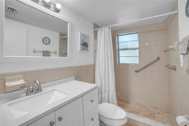 bathroom with vanity, toilet, curtained shower, and tile walls