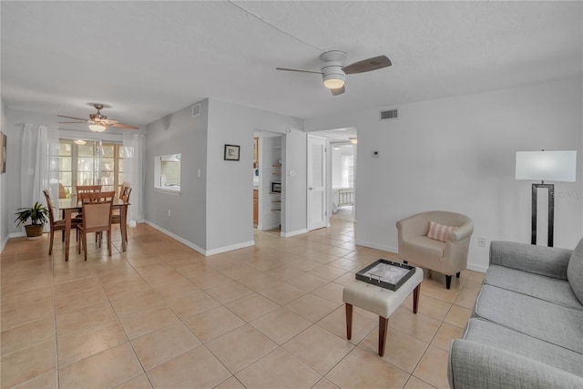 tiled living room with plenty of natural light and ceiling fan